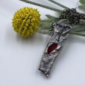 Reticulated Sterling silver hollow form with hint of red bamboo roving peeking out of center