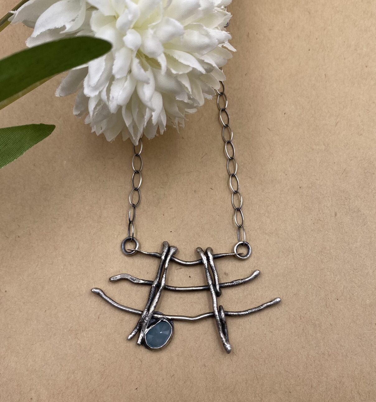 Three branches of Sterling silver connected by two bars with an aquamarine set near the bottom - on a Sterling silver chain
