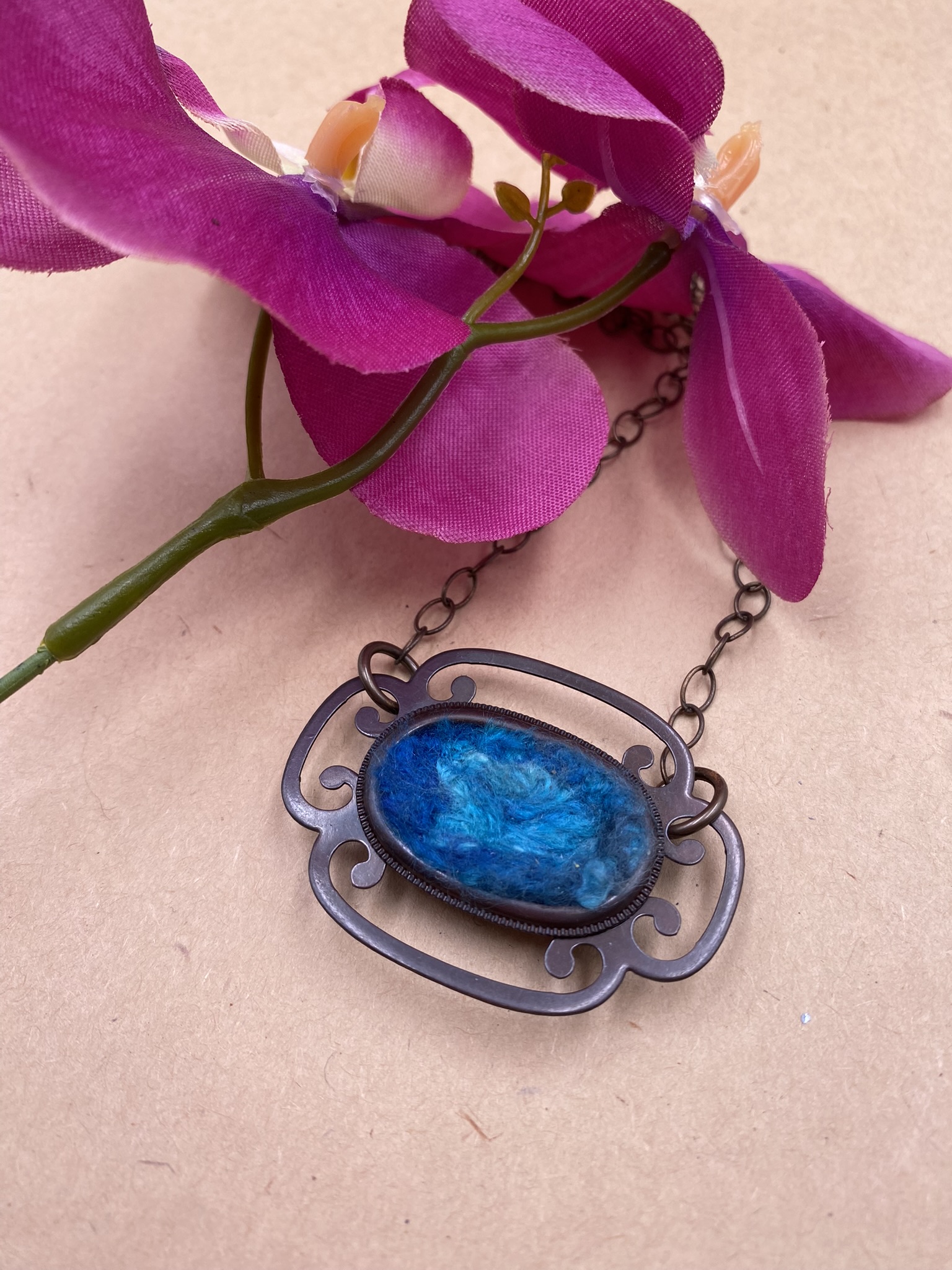 Japanese dark bronze drawer handle frame with mottled blue bamboo roving felted into the center with bronze chain.