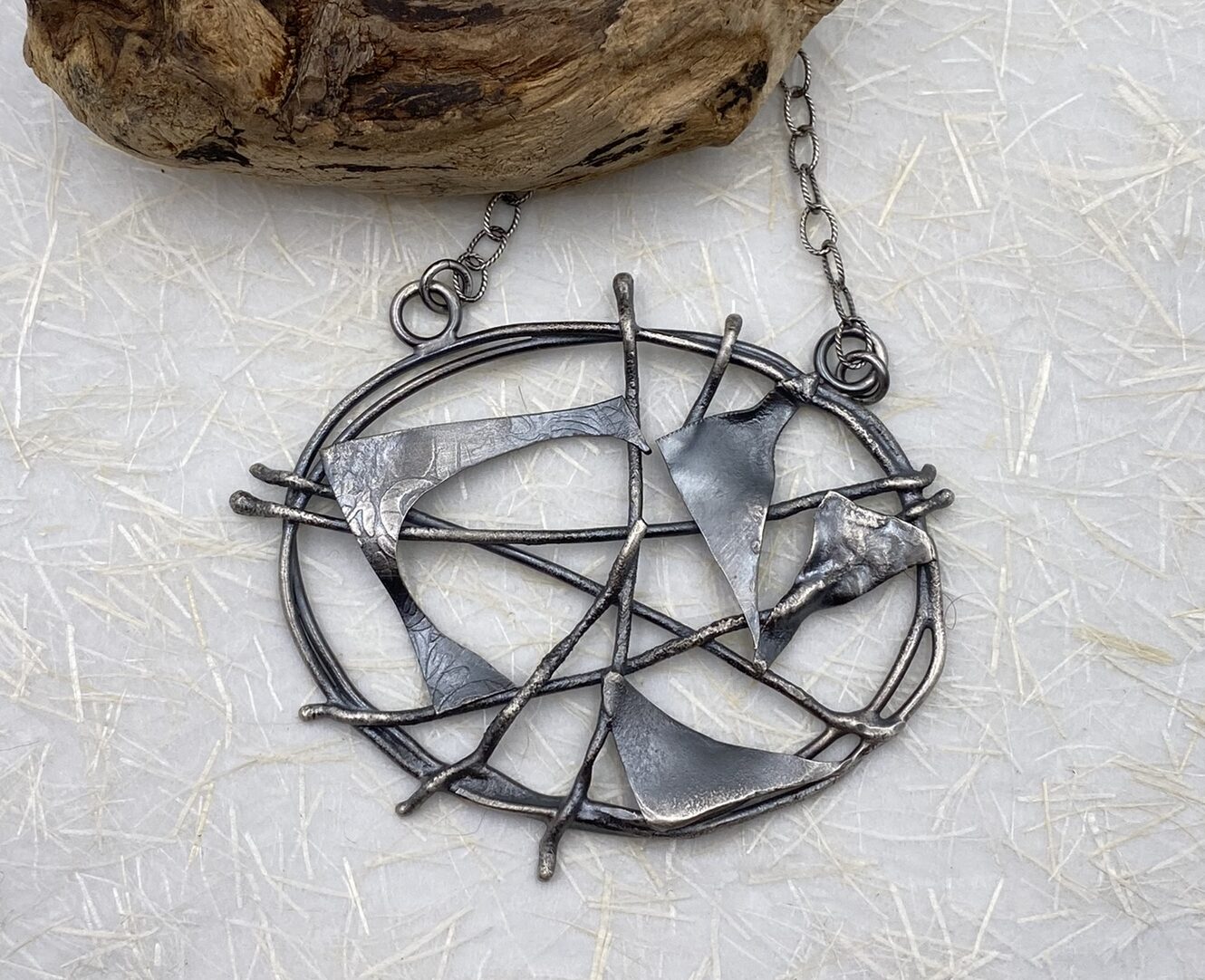 A Sterling silver oval criss-crossed by wires - some spaces filled by Sterling silver sheet.